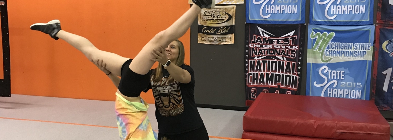 Instructor helping gymnast perform handstand